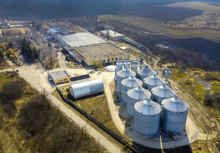 Aerial drone view of a winery metal cisterns with bare trees and fields around it in Moldova